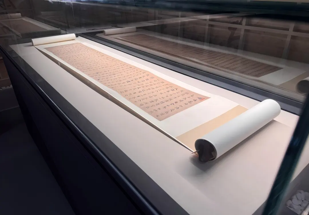 Museum conservation display case close-up, horizontal glass cabinet protecting ancient Chinese calligraphy scroll